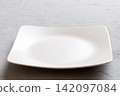 Perspective view of empty square plate on cement background. Empty space for your design 142097084