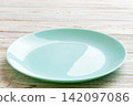 Perspective view of empty blue plate on wooden background. Empty space for your design 142097086