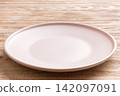 Perspective view of empty light plate on wooden background. Empty space for your design 142097091
