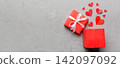Happy valentines day opened heart shape gift box with small hearts, on colored background, valentines day card - top view concept 142097092