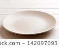 Perspective view of empty light plate on wooden background. Empty space for your design 142097093