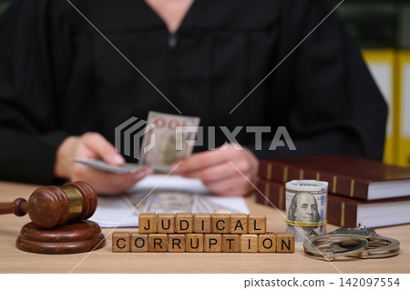 Judicial corruption exposed in the courtroom with symbols of justice and bribery Judicial corruption exposed in the courtroom with symbols of justice and bribery 142097554