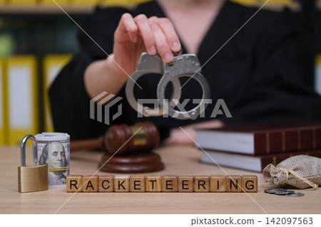 Courtroom scene showcasing the serious implications of racketeering using handcuffs and legal symbols Courtroom scene showcasing the serious implications of racketeering using handcuffs and legal symbols 142097563