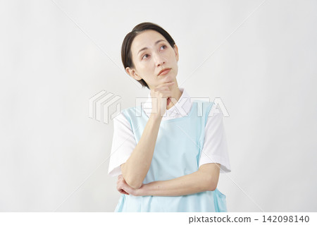 Female caregiver thinking, white background Female caregiver thinking, white background 142098140