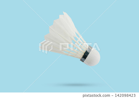 Badminton shuttlecock floating on blue background Badminton shuttlecock floating on blue background 142098423