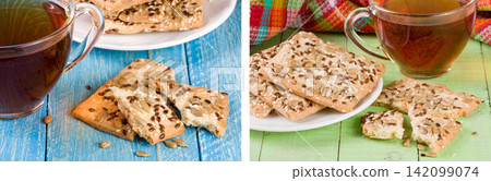 crispy bread with seeds of sunflower, flax and sesame seeds with a cup of tea on a blue and green wooden background 142099074