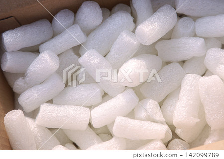 White expanded polystyrene foam packaging pieces in a cardboard box White expanded polystyrene foam packaging pieces in a cardboard box 142099789