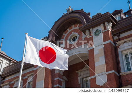 東京車站和藍天中飄揚的日本國旗。 142099837