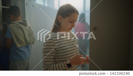 Teenage Girl Enters School Locker Room, Greets Classmates, Places Belongings in Personal Locker Teenage Girl Enters School Locker Room, Greets Classmates, Places Belongings in Personal Locker 142100290