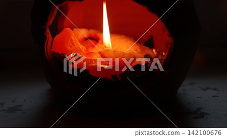 A burning candle in a candlestick. A burning candle in a candlestick. 142100676