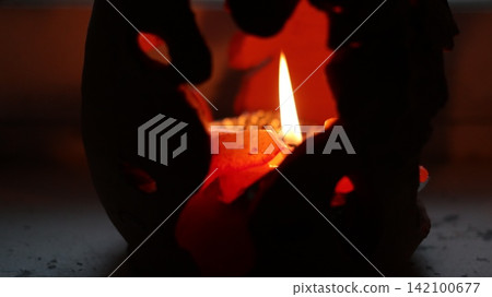 A burning candle in a candlestick. A burning candle in a candlestick. 142100677