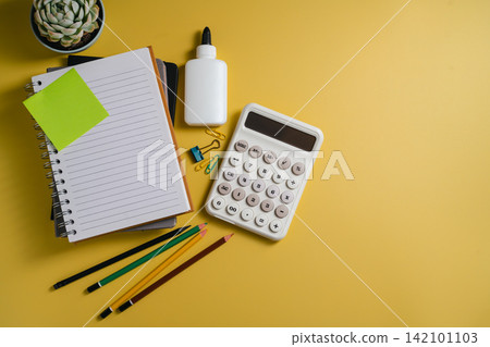 Tax planning with calculator, notebook and stationery on yellow background, flat lay with copy space Tax planning with calculator, notebook and stationery on yellow background, flat lay with copy space 142101103