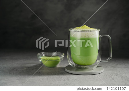 Matcha latte with green tea powder and frothy milk, matcha preparation and healthy beverage concept Matcha latte with green tea powder and frothy milk, matcha preparation and healthy beverage concept 142101107