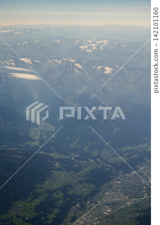 Aerial view of Swiss Alps mountains, alpine valley and town from airplane, travel and tourism Aerial view of Swiss Alps mountains, alpine valley and town from airplane, travel and tourism 142101160