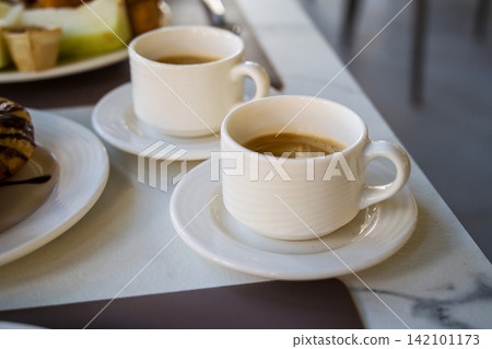 Two cups of coffee on a breakfast table, cafe travel holiday and leisure background 142101173