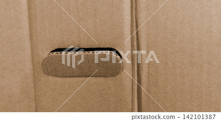 Brown corrugated cardboard texture with hand holes. Brown corrugated cardboard texture with hand holes. 142101387