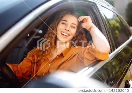 Emotional woman drives a car. The concept of fast movement, traveling by car. Emotional woman drives a car. The concept of fast movement, traveling by car. 142102040