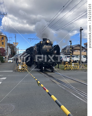 一輛蒸汽機車(SL)在藍天下的鐵軌上行駛。 一輛蒸汽機車(SL)在藍天下的鐵軌上行駛。 142103103