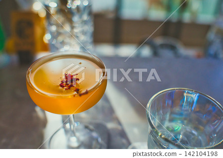 在咖啡吧的吧台享用一杯雞尾酒和水。 在咖啡吧的吧台享用一杯雞尾酒和水。 142104198