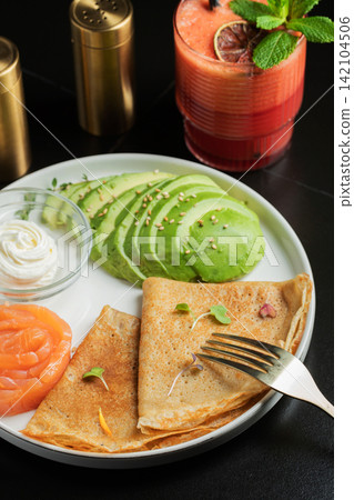 Roasted thin pancakes with smoked salmon and sauce 142104506