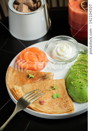 Roasted thin pancakes with smoked salmon and sauce Roasted thin pancakes with smoked salmon and sauce 142104507