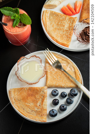 Pancakes with blueberry and honey on a white plate Pancakes with blueberry and honey on a white plate 142104509