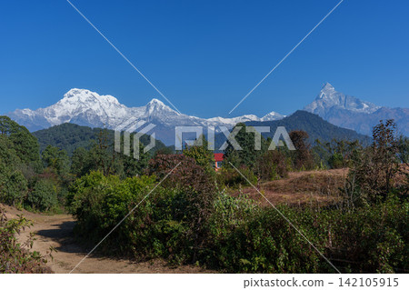 Trekking in Mardi Himal, Nepal: Views of Annapurna South and Machhapuchhre from a mountain village. Trekking in Mardi Himal, Nepal: Views of Annapurna South and Machhapuchhre from a mountain village. 142105915