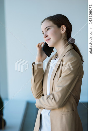 Young businesswoman talking on smartphone in office building 142106071