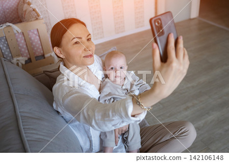Young mother capturing a selfie with her baby 142106148