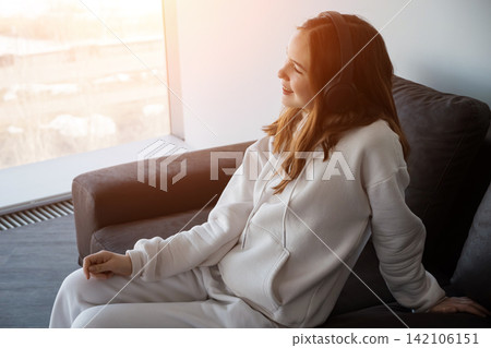 Young woman enjoying music and relaxing at home Young woman enjoying music and relaxing at home 142106151
