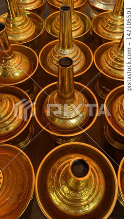 Golden brass water pouring bottle sets for Buddhist libation rite on wooden table Golden brass water pouring bottle sets for Buddhist libation rite on wooden table 142106501