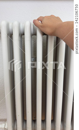 Hand checking metal radiator after painting during home repair process heating system maintenance and renovation concept Hand checking metal radiator after painting during home repair process heating system maintenance and renovation concept 142106750