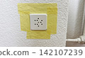 Electrical socket fully masked with yellow painter tape before home renovation safe protection for painting  142107239