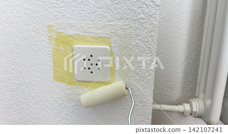 Wall socket masked with painter tape before coating surface protection for safe house renovation repair workflow electrical safety step clean Wall socket masked with painter tape before coating surface protection for safe house renovation repair workflow electrical safety step clean 142107241
