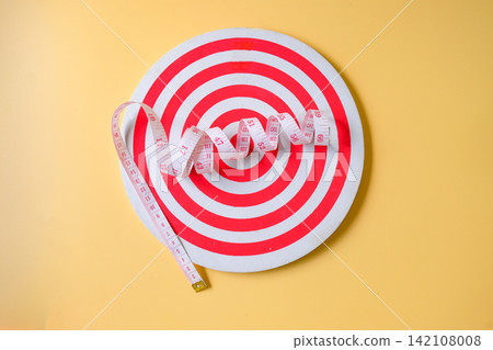 A measuring tape on dartboard game ,health concept. A measuring tape on dartboard game ,health concept. 142108008