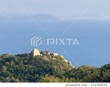 山巒岩石地形和茂密森林,以蔚藍的大海為背景:這是日本的自然景觀。 山巒岩石地形和茂密森林,以蔚藍的大海為背景:這是日本的自然景觀。 142108526