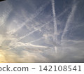 Contrails crossing the twilight sky and fantastical clouds 142108541