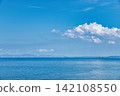 The sea with wind turbines visible in the distance and summer clouds. 142108550