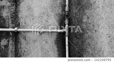 Monochrome water pipes on a textured concrete wall. Monochrome water pipes on a textured concrete wall. 142109795