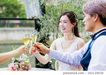 一張新郎新娘與朋友一起喝香檳的婚禮照片。 一張新郎新娘與朋友一起喝香檳的婚禮照片。 142110016