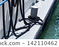 Mooring rope tied to a bollard on a boat deck, illustrating the boat docking and mooring process in practical waterfront settings. 142110462