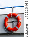 Bright orange lifebuoy on board a boat, representing water transport and the boating setting in a clean maritime environment. 142110463