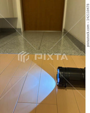 一個LED手電筒,設定為手電筒模式,用來照亮地面。 一個LED手電筒,設定為手電筒模式,用來照亮地面。 142110478