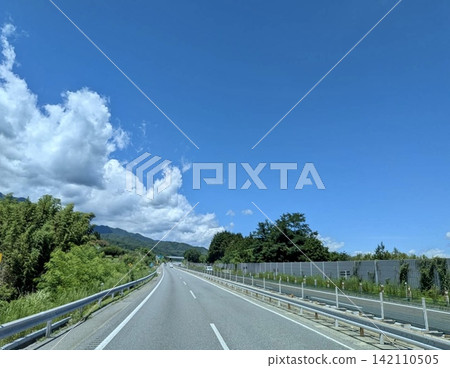 A highway running through the summer blue sky and greenery. A highway running through the summer blue sky and greenery. 142110505