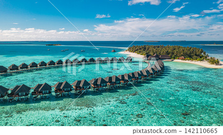 Serene aerial view overwater villa loop stretching calm azure Maldives lagoon tropical reef resort. Luxury travel destination landscape scenic. Exotic getaway drone vista wallpaper Serene aerial view overwater villa loop stretching calm azure Maldives lagoon tropical reef resort. Luxury travel destination landscape scenic. Exotic getaway drone vista wallpaper 142110665