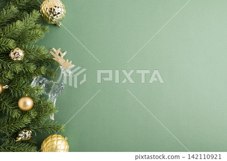 Christmas festive border with fir branches gold baubles and reindeer on pastel background Christmas festive border with fir branches gold baubles and reindeer on pastel background 142110921