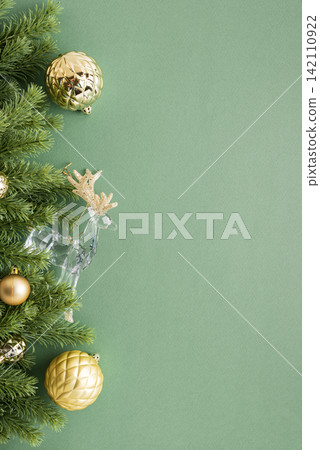 Christmas pine branch with golden ornaments and crystal reindeer isolated on sage green background greeting card design Christmas pine branch with golden ornaments and crystal reindeer isolated on sage green background greeting card design 142110922