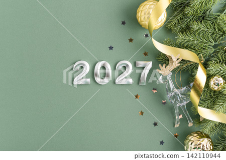 New Year 2027 celebration festive decorations and sparkling ornaments on a soft green background with copy space New Year 2027 celebration festive decorations and sparkling ornaments on a soft green background with copy space 142110944