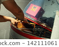 Beekeeper loading wooden frame with honeycomb into centrifugal honey extractor machine 142111061