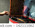 Beekeeper loading wooden frame with honeycomb into centrifugal honey extractor machine 142111062